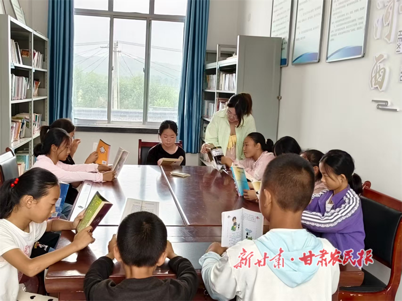 河西镇“青年之家”里孩子们围坐在一起看书.png